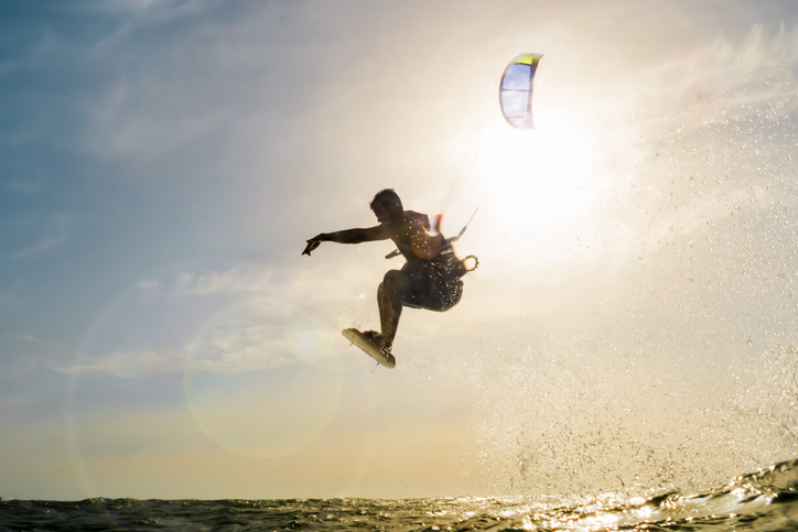 Surfer flying in front of the sunset