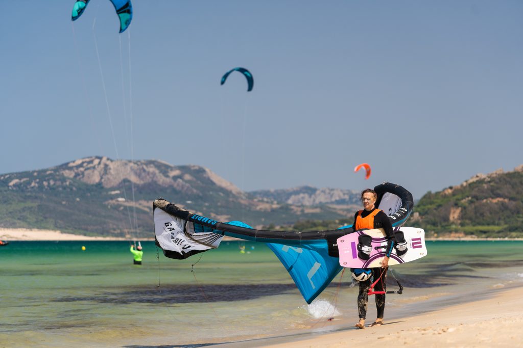 Kite camp: Kite student walking upwind with kite in hand